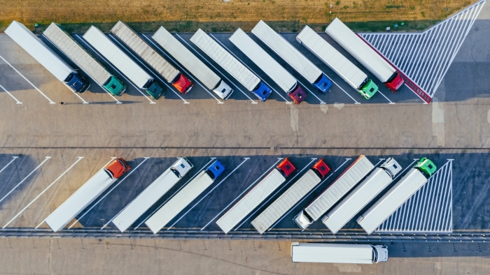 Aerial view of a parking lot with several big cargo trucks.